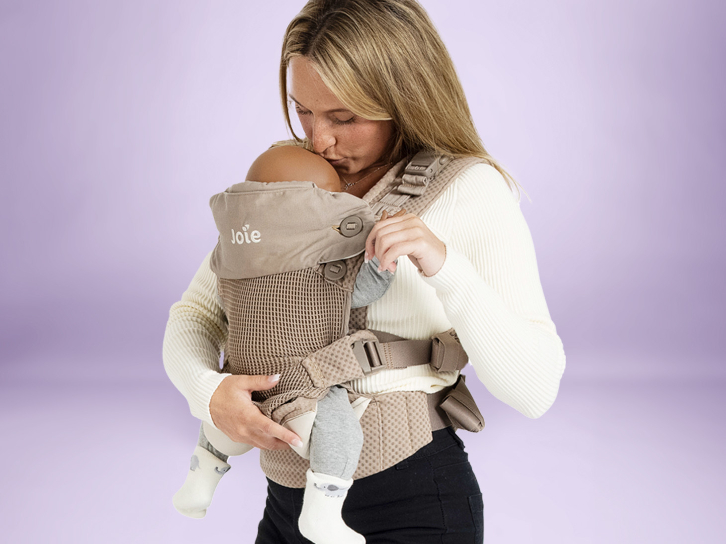 Baby in savvy lite air 3-in-1 carrier with hood in sandstone on mom's front on purple background