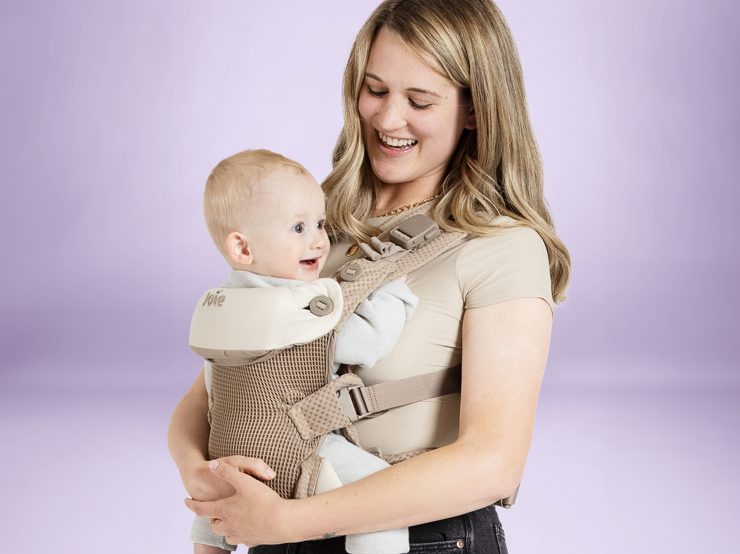 Baby in savvy lite air 3-in-1 carrier in sandstone on mom's front on purple background