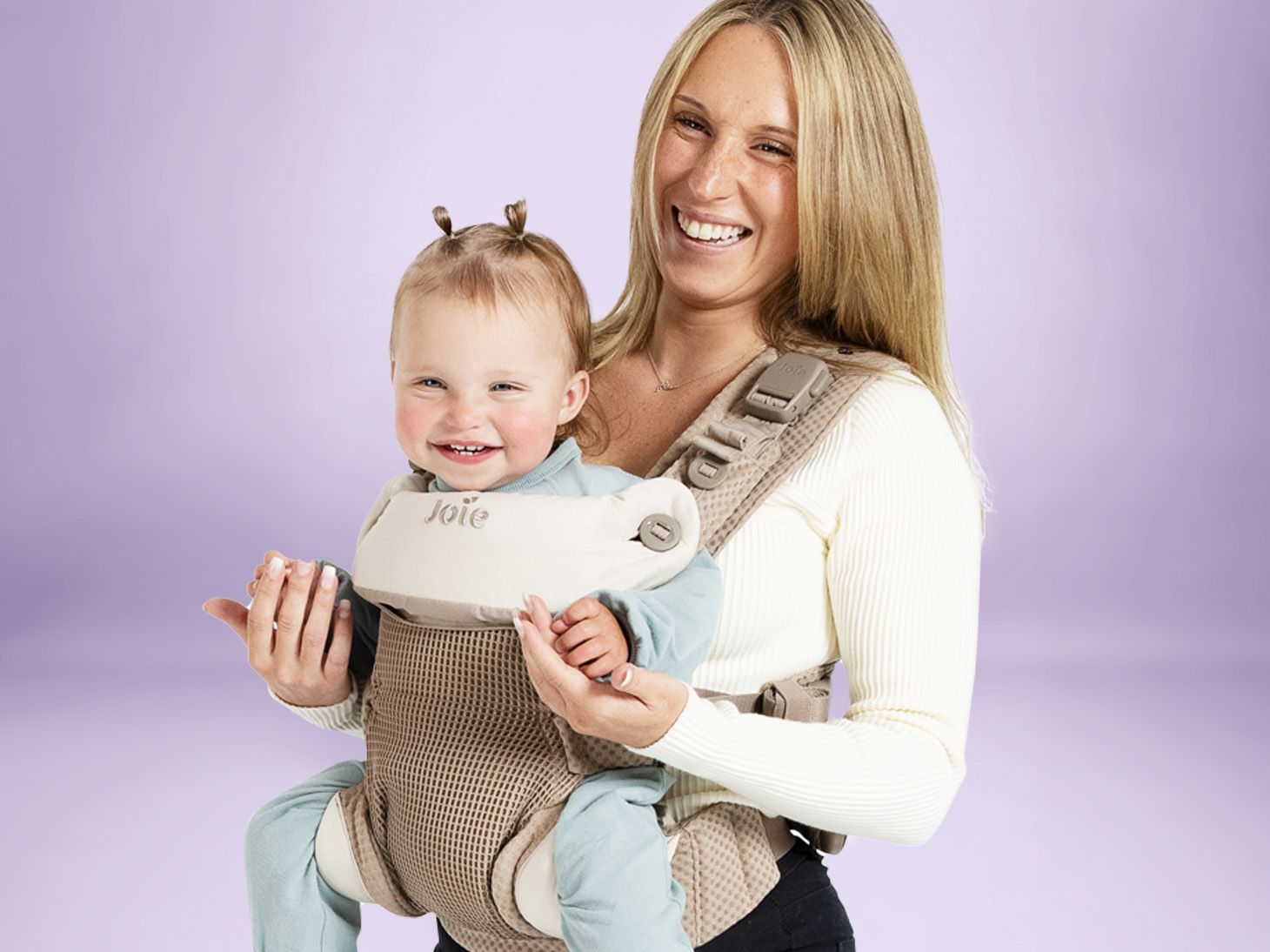 Baby in savvy lite air 3-in-1 carrier in sandstone on mom's front on purple background