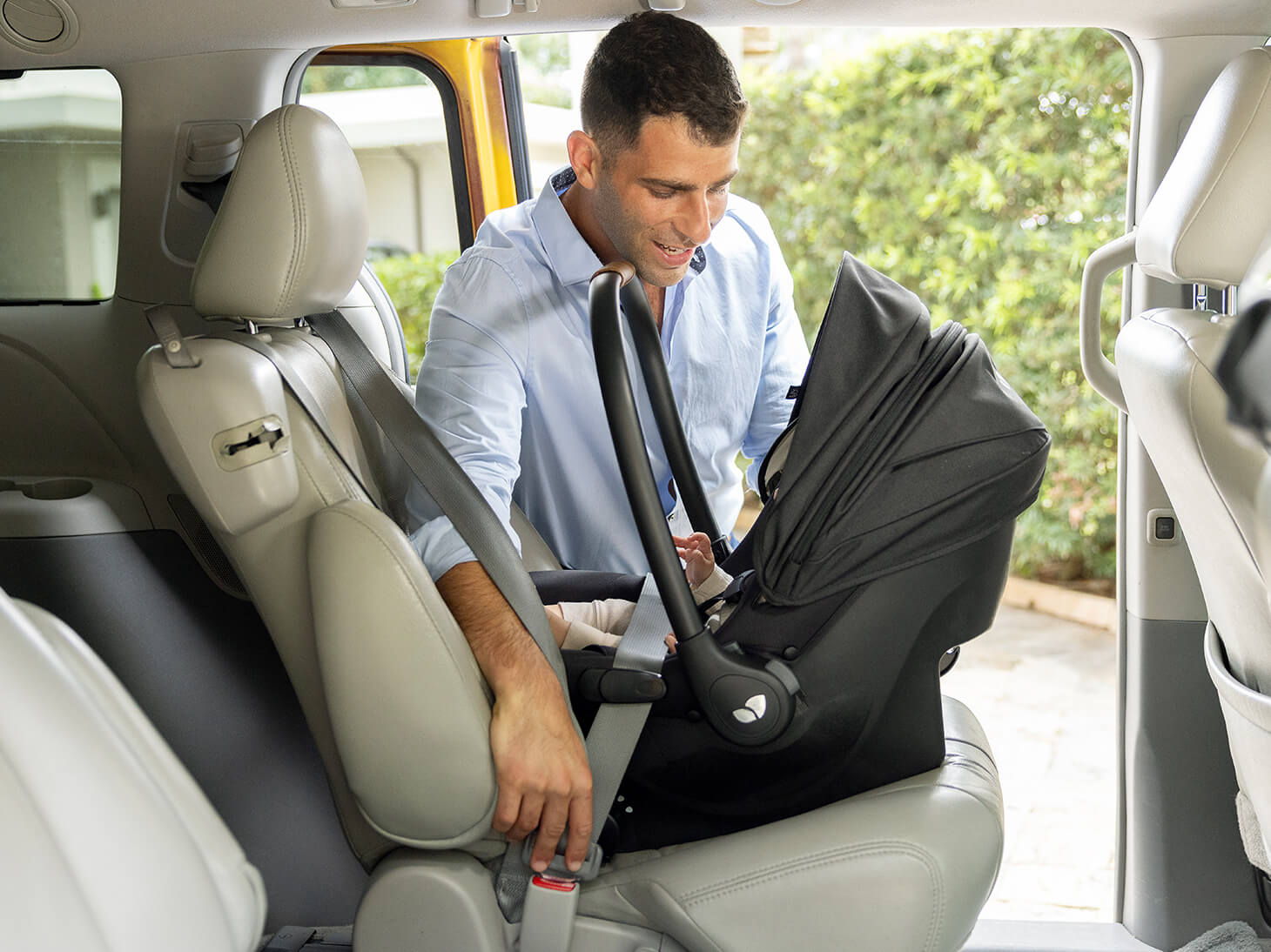 Parent putting baby in car in mint latch 
