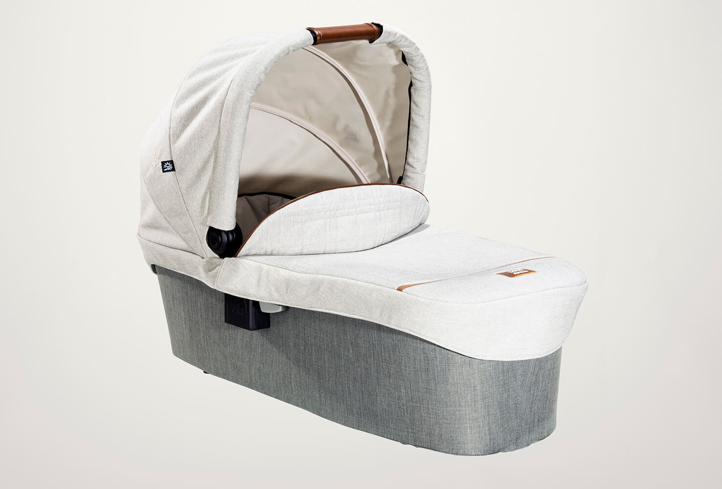 Joie Signature ramble carry cot in light gray at a right angle with hood raised.
