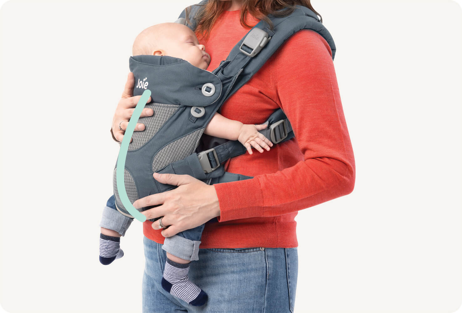 Primer plano de un bebé en una mochila portabebés Joie Savvy 4in1 azul con una línea color verde menta que indica la forma de C de la columna vertebral del bebé