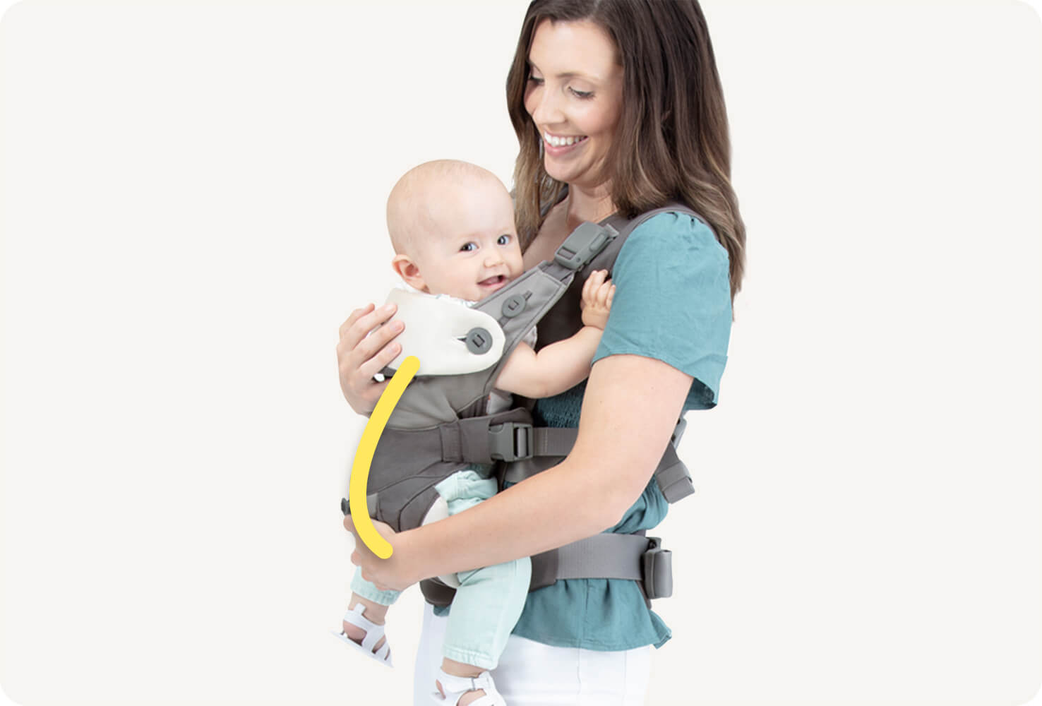 Nahaufnahme eines Babys in einer grauen Joie Savvy Lite 3in1 Babytrage mit einer gelben Linie, die die C-Form der Wirbelsäule des Babys anzeigt