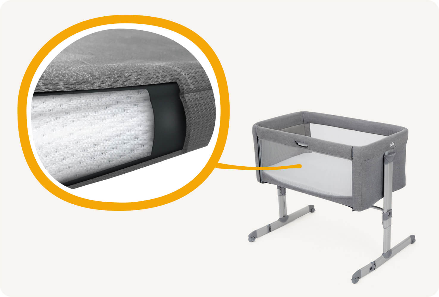 Gros plan sur un cercle orange montrant le matelas du lit d’appoint Joie roomie, coloris gris clair.