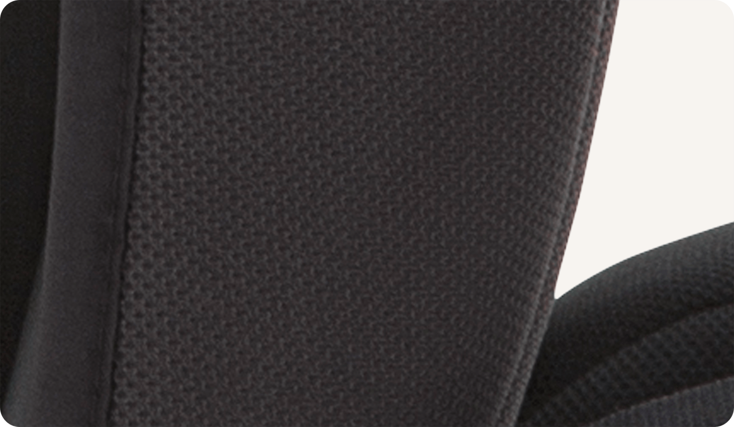 Gros plan sur le tissu d’aération en tissu maille noir du rehausseur de siège auto Joie Elevate.