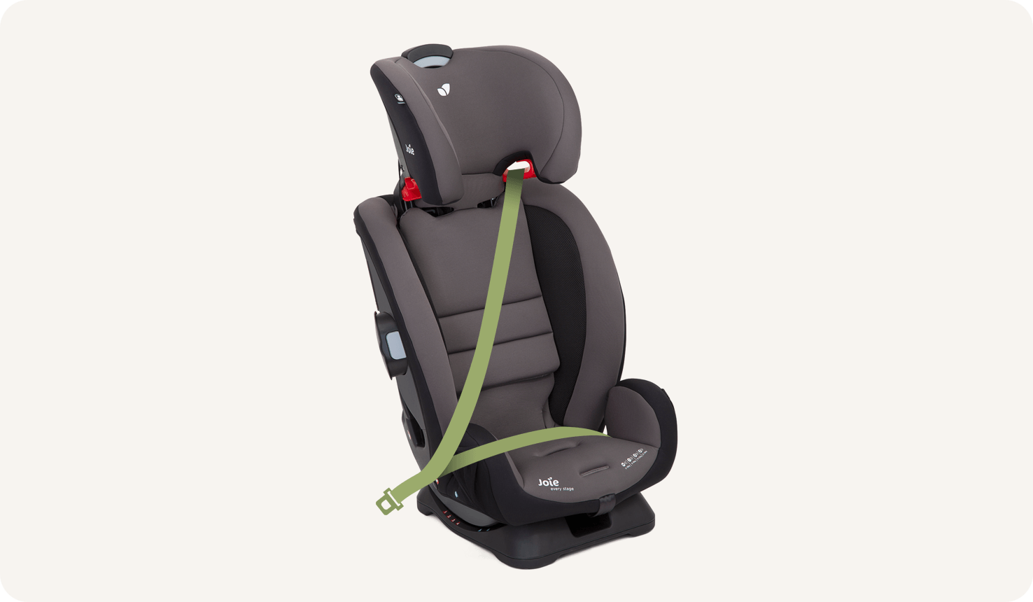Una silla de coche Joie Every Stage de color negro y gris con el arnés oculto y un cinturón de coche animado verde que sujeta la silla.