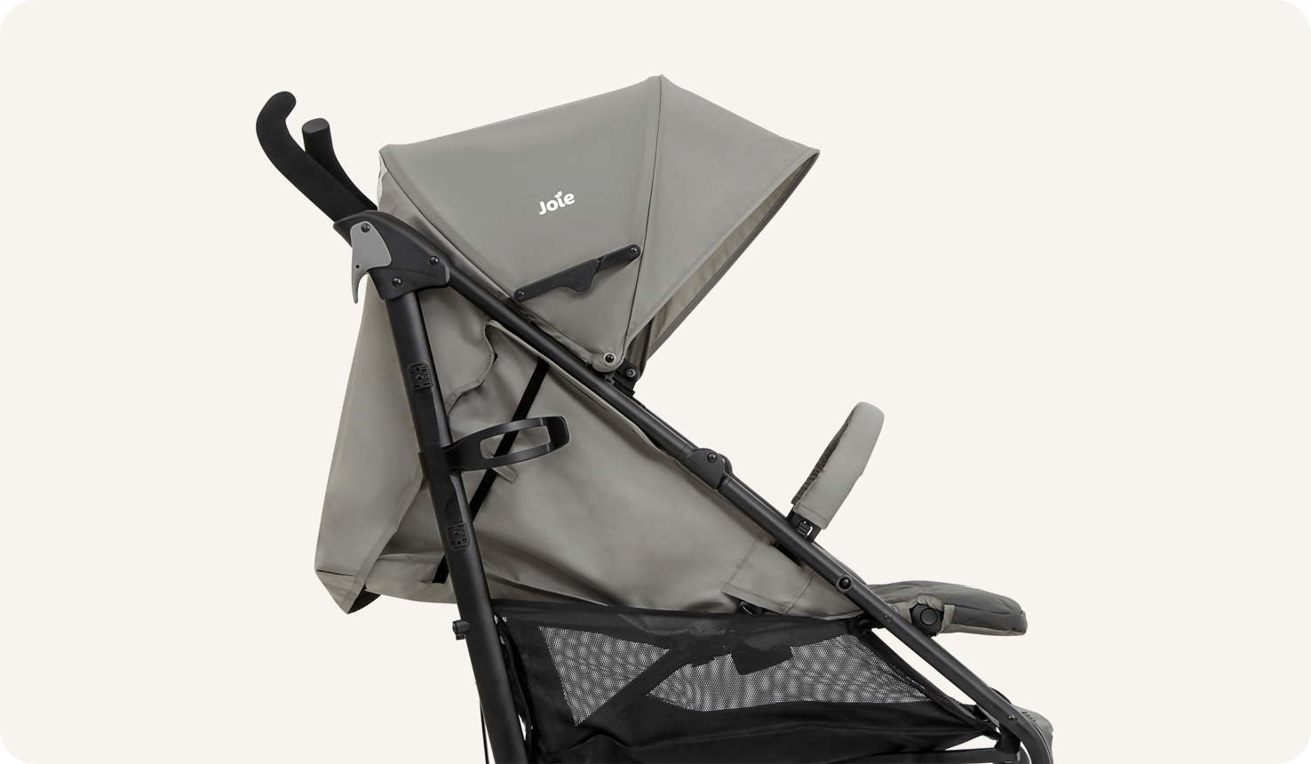 Un primer plano del cochecito Joie Brisk LX en dos tonos de gris, de perfil, orientado a la derecha con el asiento totalmente reclinado.