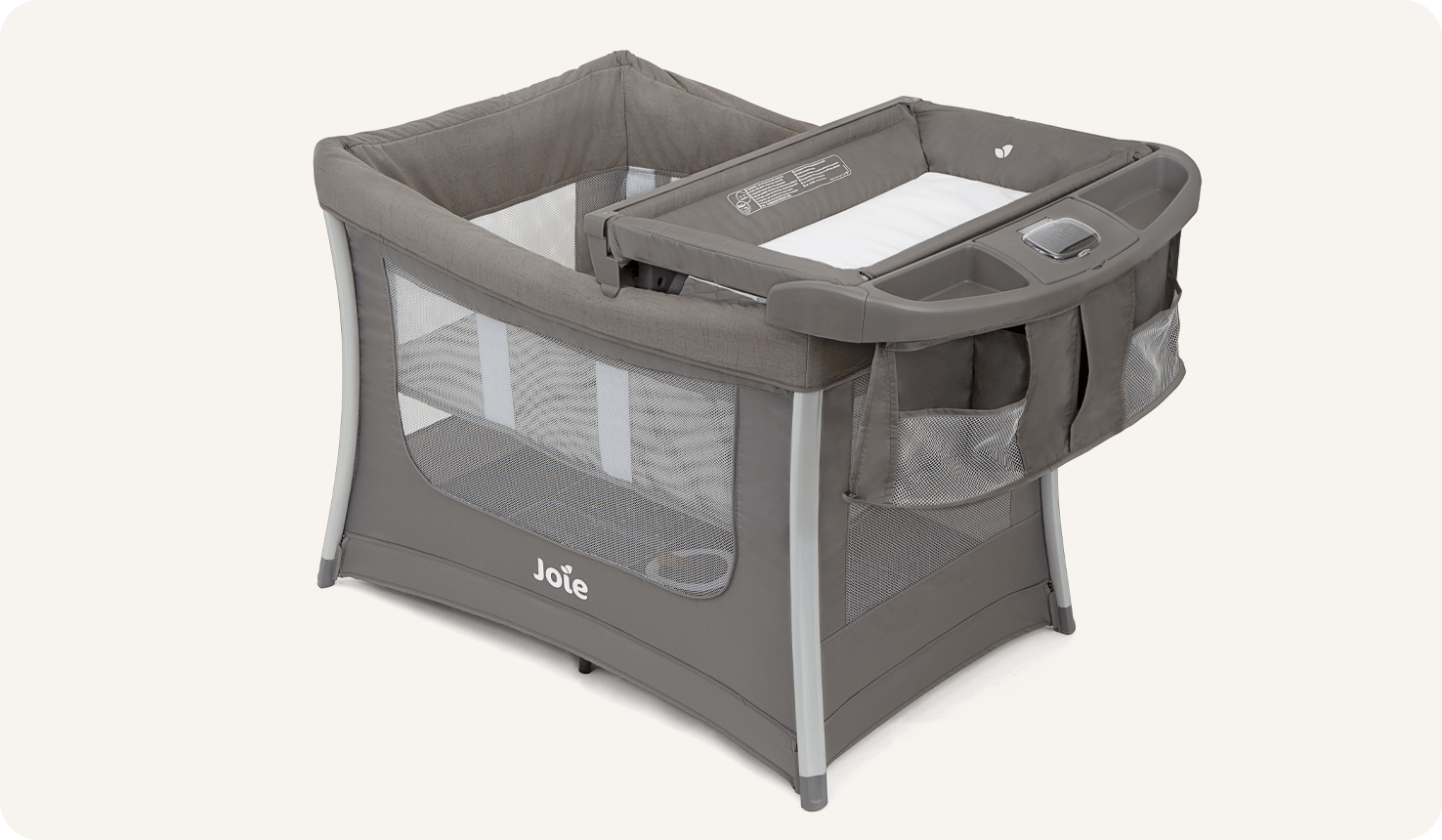 The Joie travel cot illusion with bassinet insert and changing table storage on top in dark gray from a left angle.