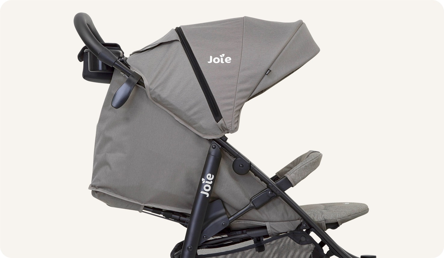 Closeup on a black Joie Litetrax 4 stroller, facing toward the right in profile, fully reclined and with the canopy extended.