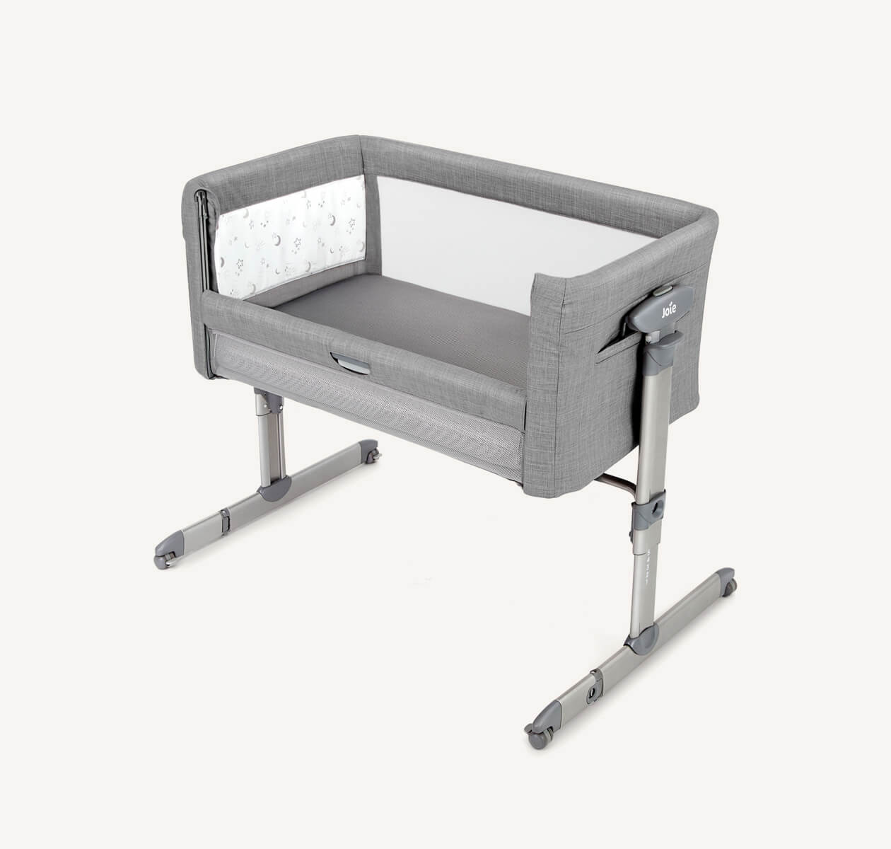Light grey Joie roomie glide bedside crib at a right angle, with lift and lower side panel down.