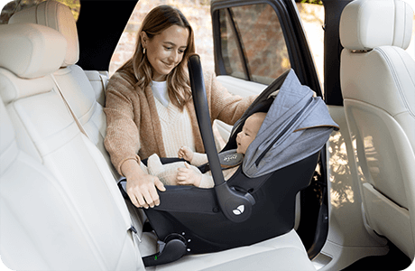 Bébé dans Sprint installé sur le siège arrière de la voiture par une mère joyeuse.