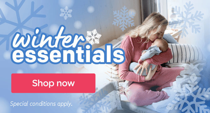 image of a mother holding baby snuggled in bed with text referencing winter essentials