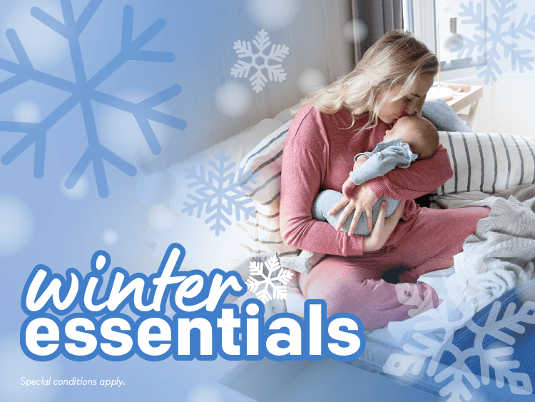 image of a mother holding baby snuggled in bed with text referencing winter essentials 